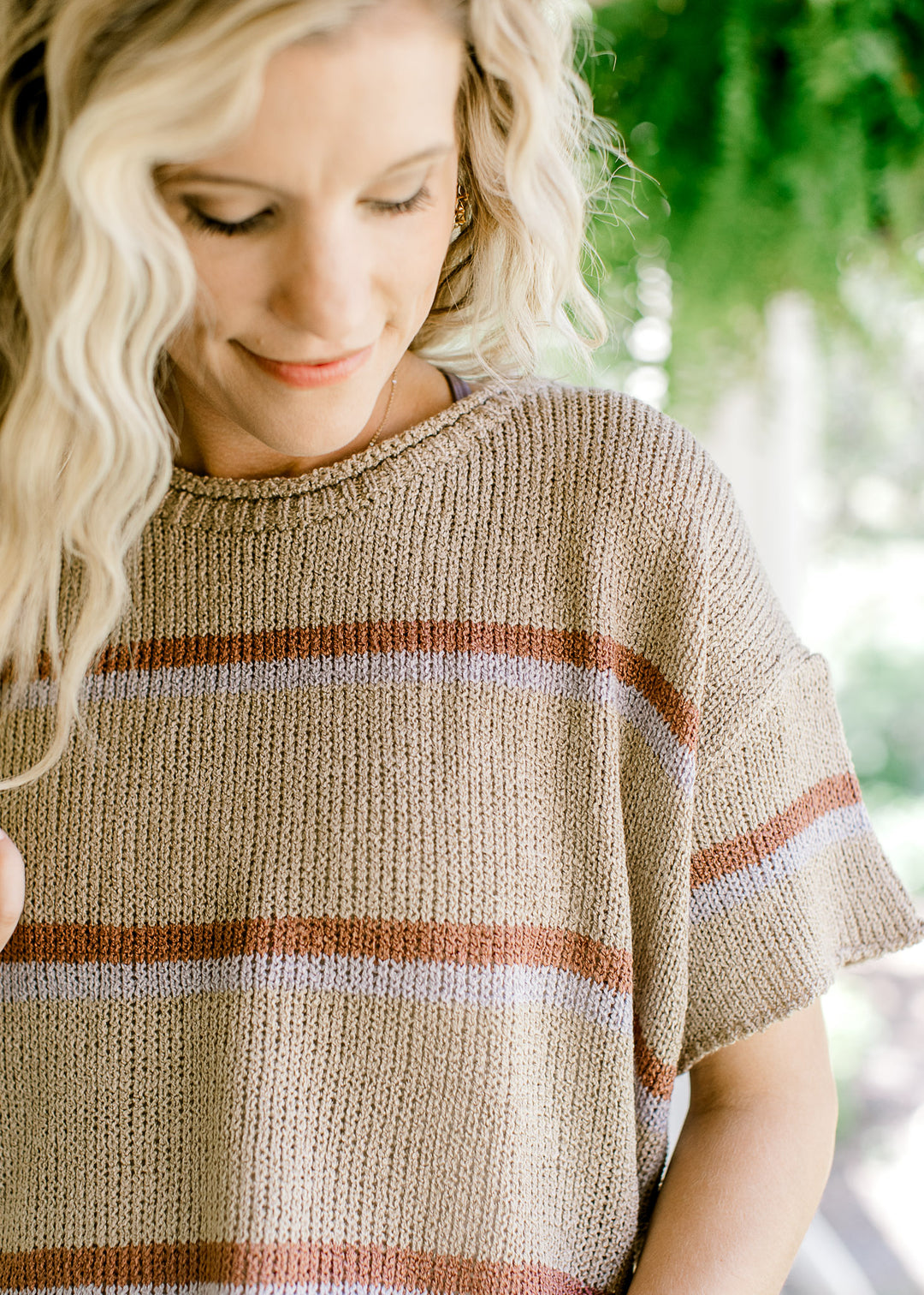 Close up of ribbed woven taupe top with brown and gray stripes and short sleeves.