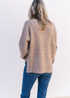 Back view of Model wearing a taupe sweater with ribbed detailing, a round neck and long sleeves.