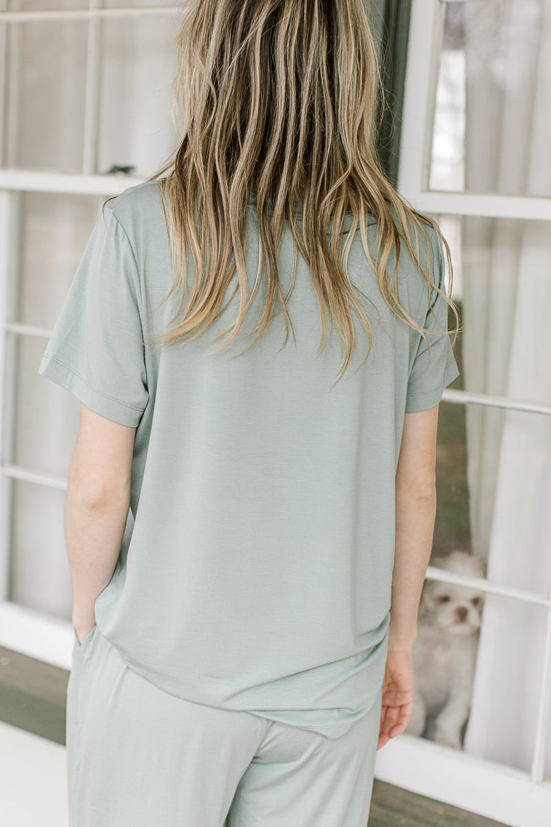 Back view of short sleeve crew neck top in a mossy green color with matching wide leg bottoms.