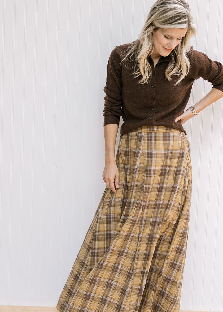 Model wearing a flowy gold and brown plaid midi with gored sides, elastic in back and side zipper. 