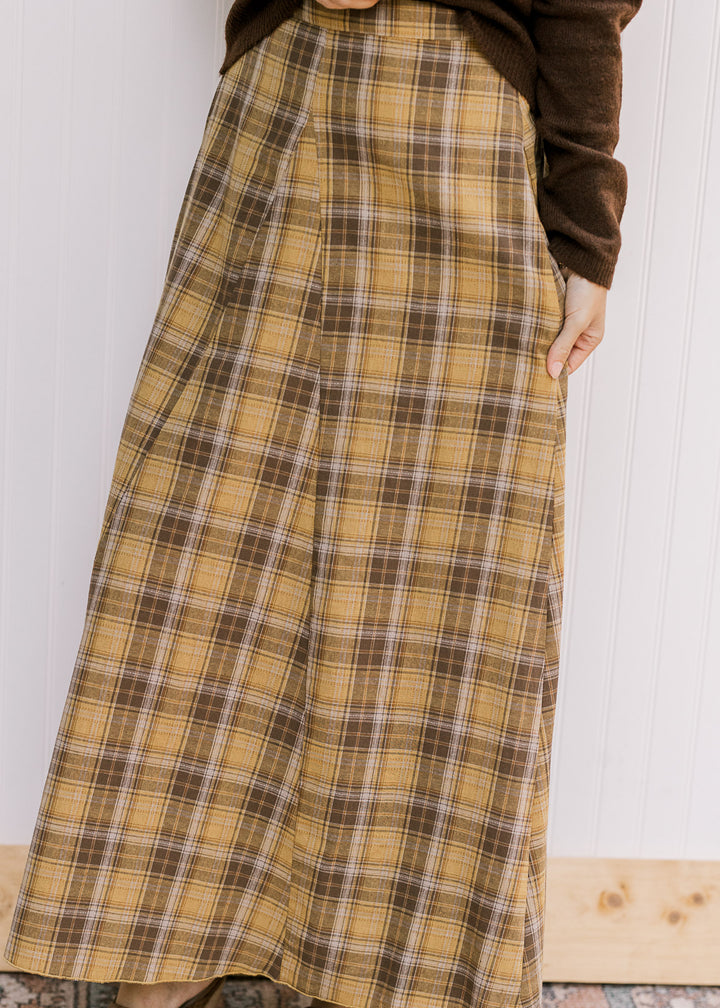 Close up of gold and brown plaid on a midi with gored side panels, elastic in back and side zipper. 