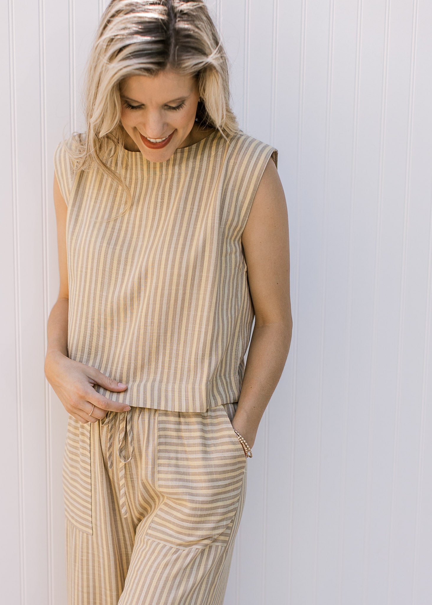 Close up of sleeveless top and wide leg bottoms with contrasting pockets on a yellow pants set.