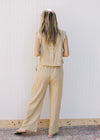 Back view of a cream and yellow striped pants set with buttons along the back of the top.