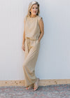 Model wearing a cream and yellow striped pants set with a sleeveless top and wide leg bottoms. 
