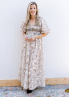 Model wearing a cream maxi with brown floral, bubble short sleeves and a smocked bust. 