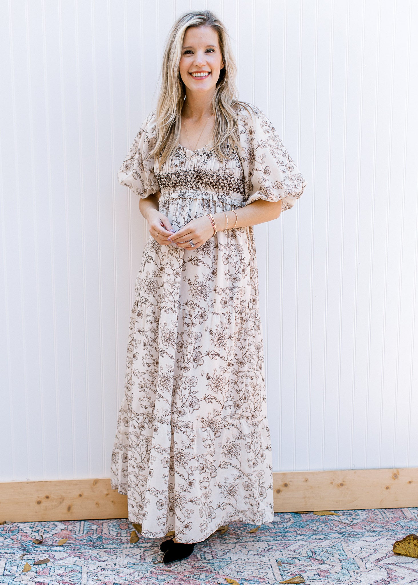 Model wearing a cream maxi with brown floral, bubble short sleeves and a smocked bust. 