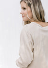 Close up of round neck on a model wearing a taupe lightweight long sleeve sweatshirt. 
