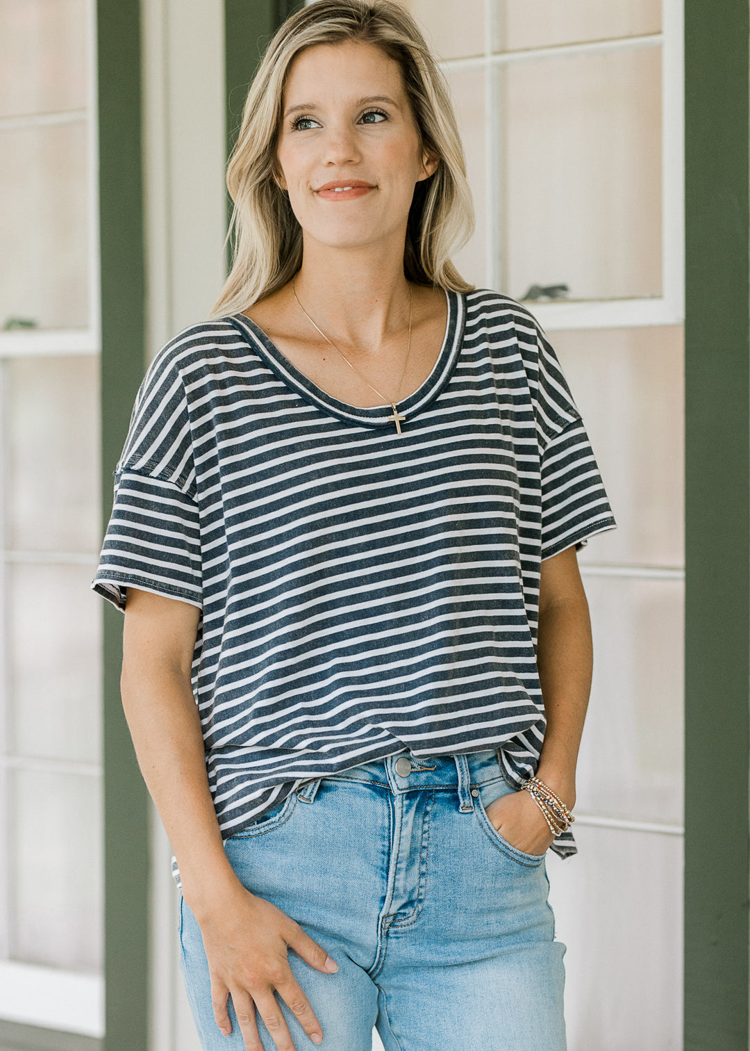 Close up of model wearing a navy and white striped tee with a scoop neck and short sleeve. 