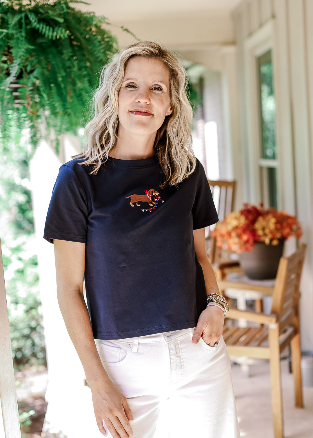 Model wearing a navy top with an embroidered Dachshund, round neck and short sleeves.