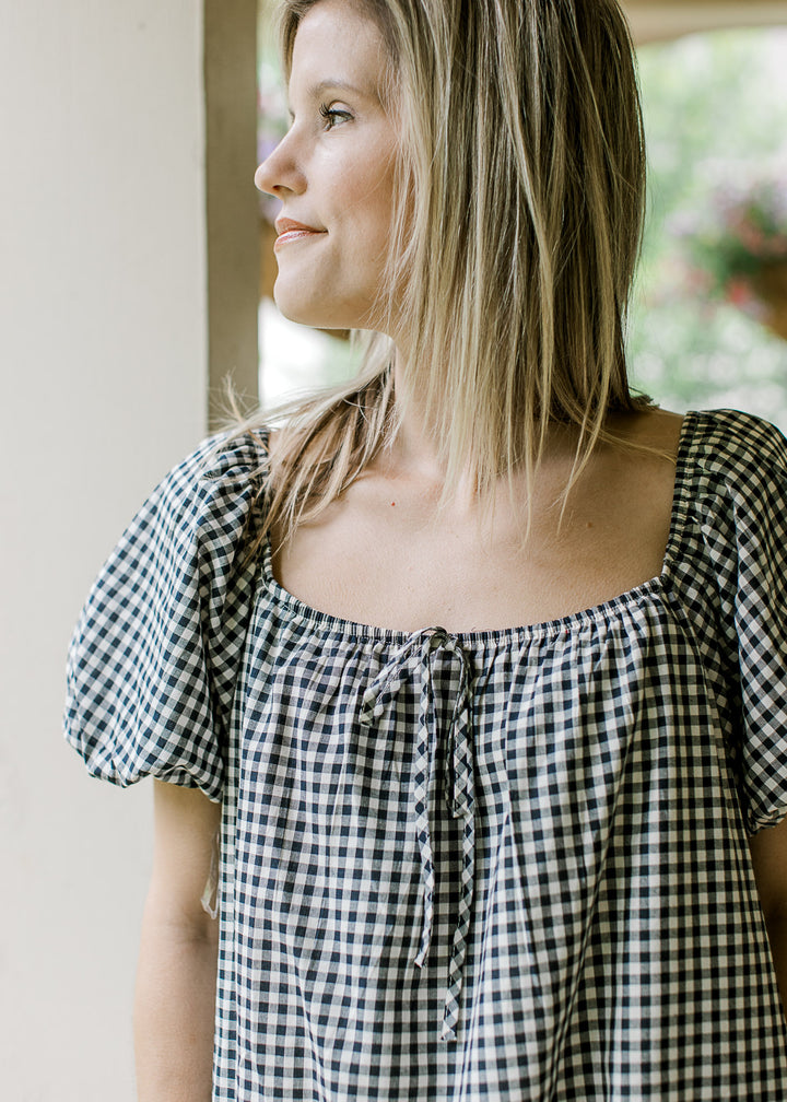 Bubble short sleeves and square neck on a navy and cream gingham above the knee dress. 