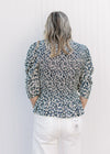 Back view of Model wearing a navy top with micro-floral print and elbow length sleeves.