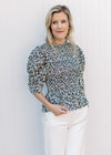 Model wearing white jeans and a navy top with micro-floral print and elbow length sleeves.