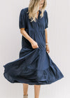 Model wearing a tiered navy dress with a v-neck and bubble short sleeves. 