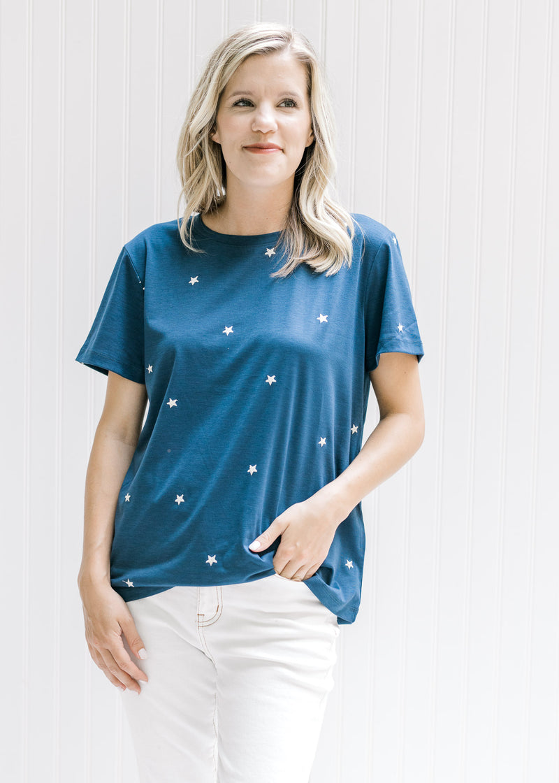 Model wearing a navy polyester top with cream embroidered stars a round neck and short sleeves. 