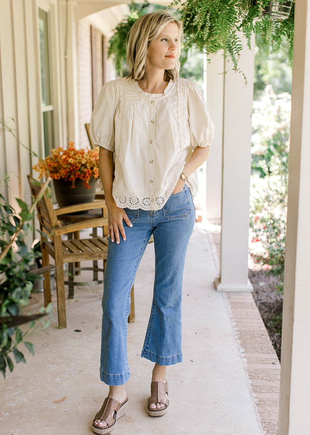 Model wearing jeans and oatmeal top with lace detail, bubble short sleeves and eyelet hem. 