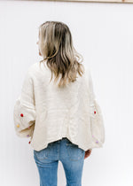 Back view of Model wearing an oatmeal open front cardigan with bubble long sleeves. 