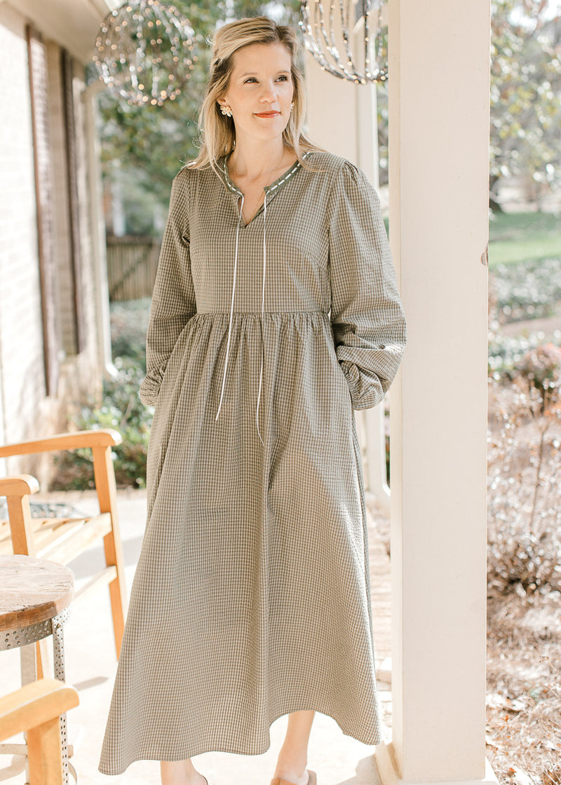 Model wearing heels and an olive and ivory checked midi with bubble long sleeves and v-neck.