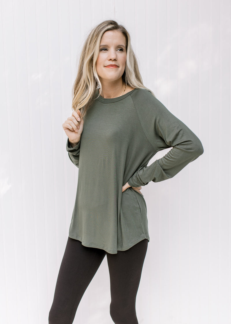 Model wearing an olive top with a round neck, long sleeves and a bamboo viscose material. 