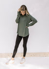 Model wearing black leggings with an olive top with a round neck, long sleeves and bamboo material.