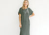 Model wearing a corded olive midi with cuff short sleeves and a round neck. 
