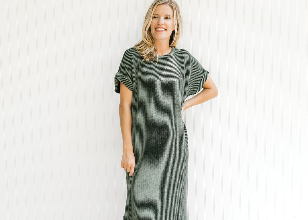 Model wearing a corded olive midi with cuff short sleeves and a round neck. 