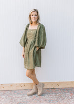 Model wearing booties with an olive dress with eyelet detail, square neck and 3/4 sleeves.