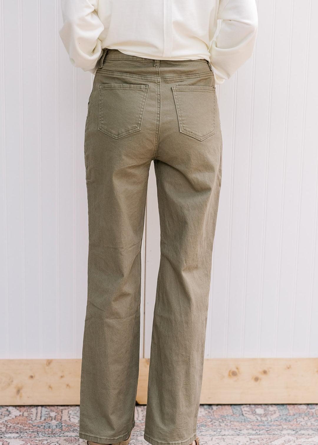 Back view of model in olive denim with a straight-leg fit and slightly stretchy material. 