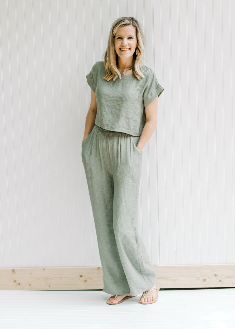 Model wearing an olive green set, the top has a crop fit and the bottom has wide leg pants. 