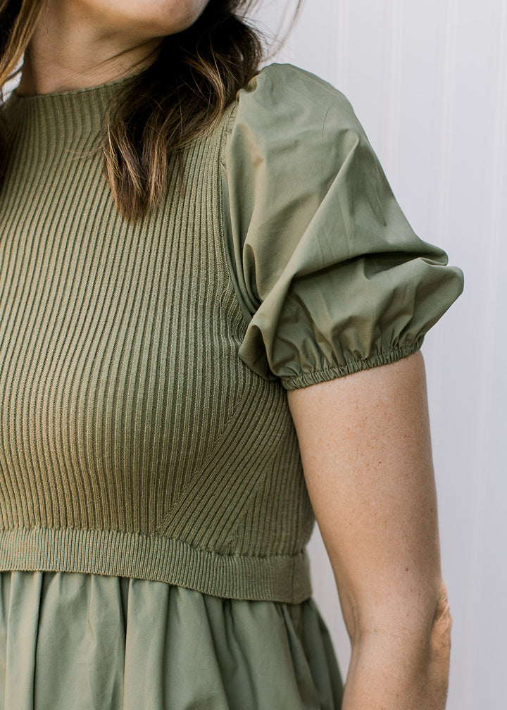 Close up of short sleeve with elastic and ribbed bodice on an olive midi. 