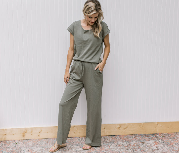 Model wearing an olive set, the top has cuff sleeves,  bottoms are wide leg with a tie and pockets.
