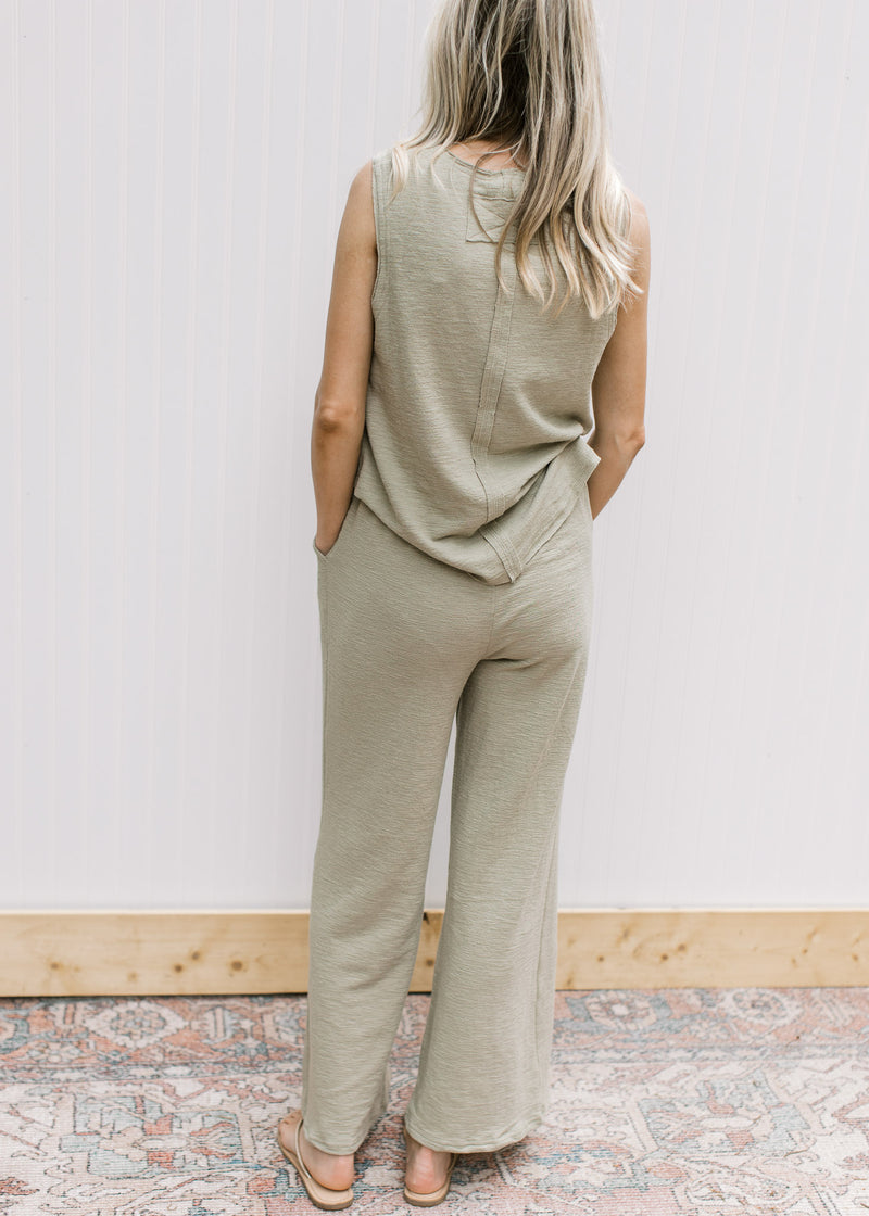 Back view of Model wearing a light olive set, top is sleeveles and wide leg bottoms with elastic.