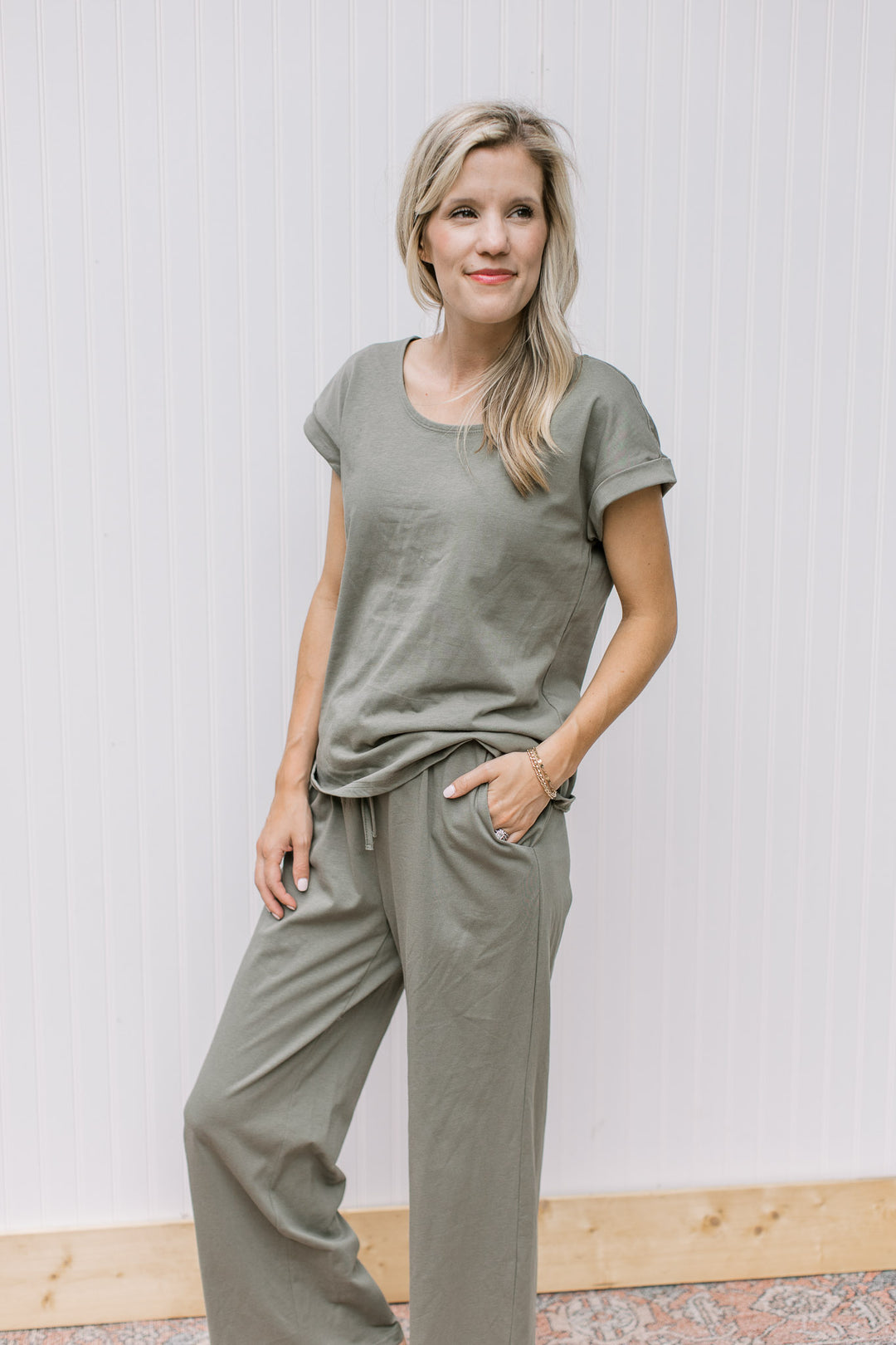 Model wearing an comfy olive set, the top has cuff sleeves and the bottoms are wide leg with a tie.