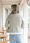 Back view of Model wearing a soft olive cardigan with scalloped edging, v-neck and long sleeves.