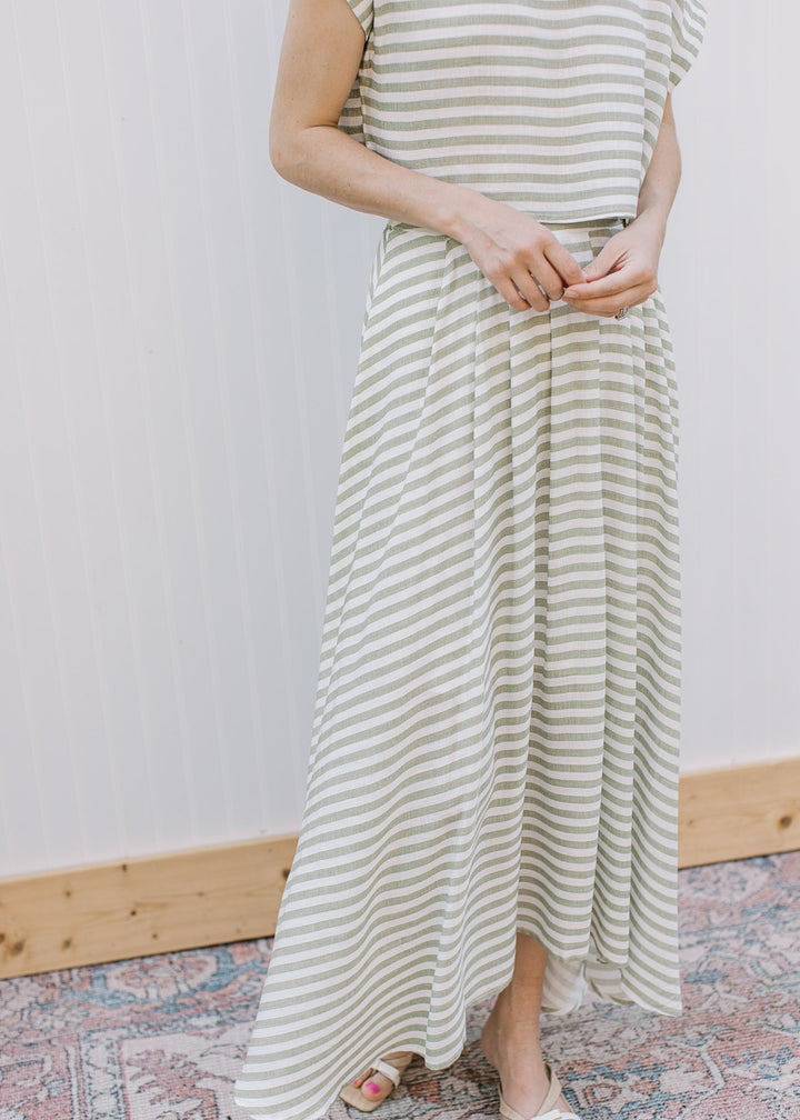 Close up of olive and cream striped midi skirt with elastic waistband, pleating and matching top.