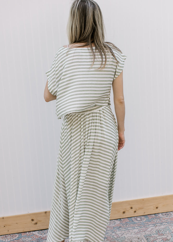Back view of model wearing an olive green and white stripe set, with boatneck top and midi skirt.