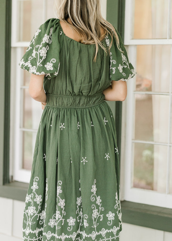 Back view of hunter green above the knee dress with cream embroidery and bubble short sleeves.