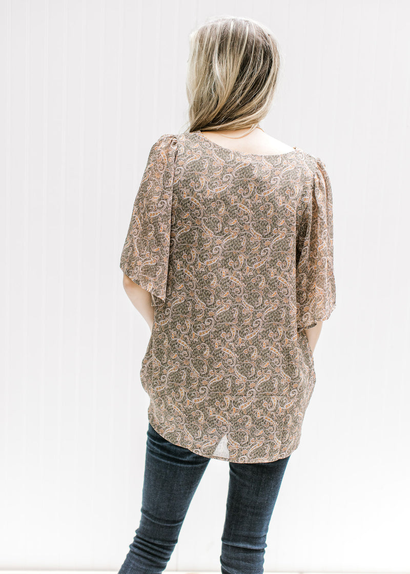 Back view of a model wearing a sage lined top with a tan paisley print, batwing sheer short sleeves