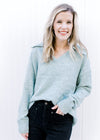 Model wearing a pale blue polyester sweater with an exaggerated collar, long sleeves and a v-neck. 