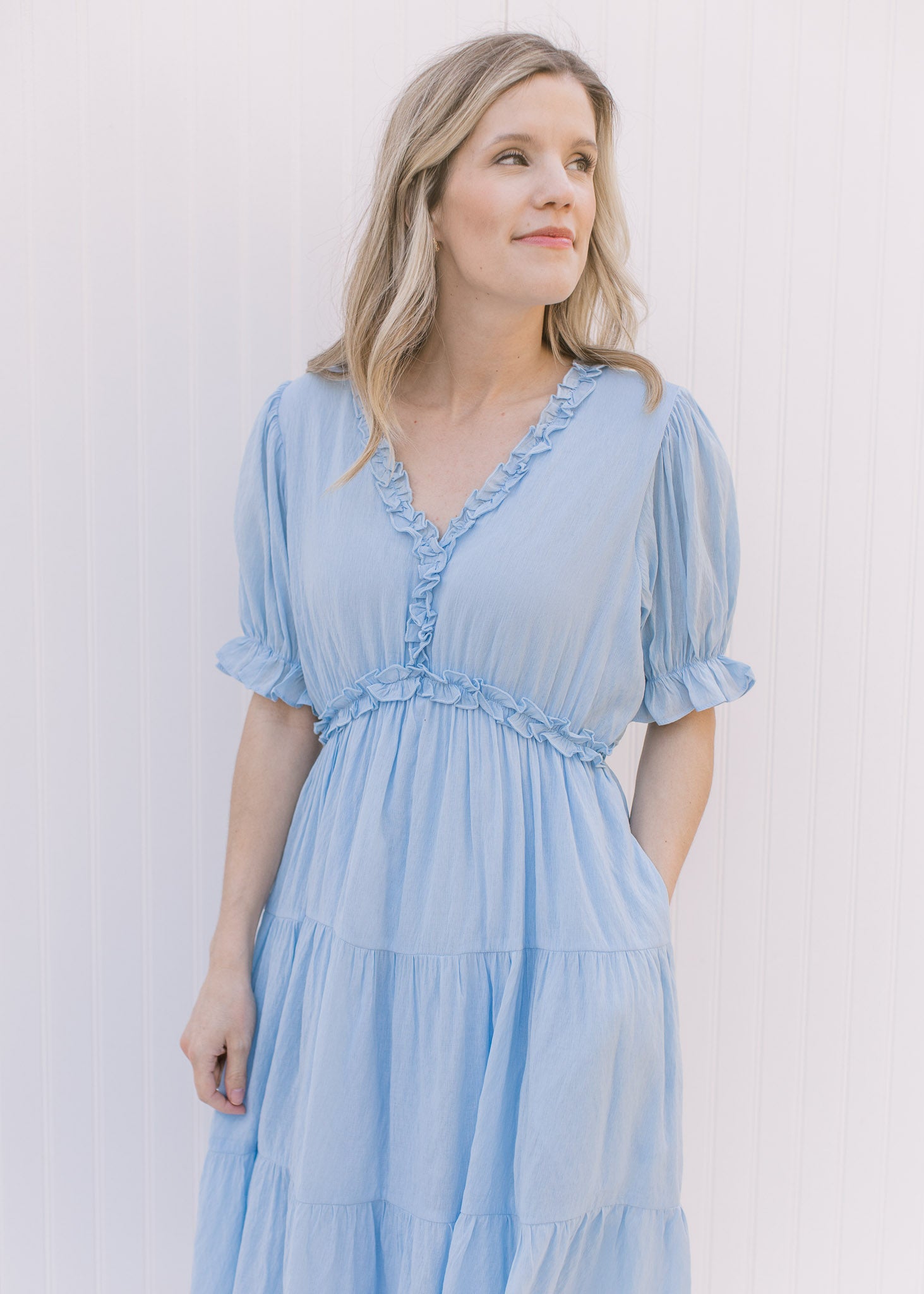 Close up of ruffles at neck and waist on a pale blue midi with poet short sleeves.