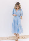 Model wearing a pale blue midi with ruffle v-neck and ruffle poet short sleeves.