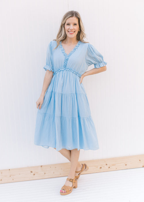 Model wearing heels with a pale blue midi with ruffle v-neck and ruffle poet short sleeves.