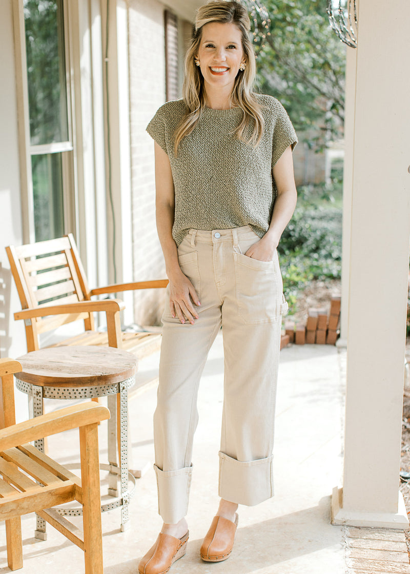 Model wearing khaki’s, mules and a pale sage knit sweater with capped sleeve and a round neck. 