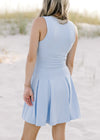 Back view of Model wearing a light blue, v-neck, sleeveless dress with a built in bra.