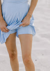 Close up of detached shorts with phone pockets, under a light blue dress.