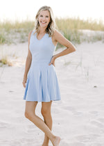 Model wearing a light blue, v-neck, sleeveless dress with a built in bra.