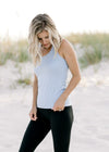 Model wearing a light blue racer back workout tank with black pants.