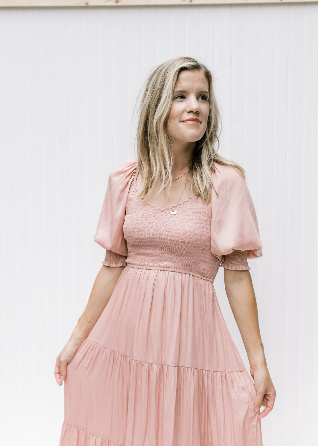 Close up of smocked bodice and bubble short sleeves with smocked band on a blush midi dress. 