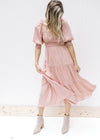 Model wearing booties with a blush, midi dress with a smocked bodice and bubble short sleeves.
