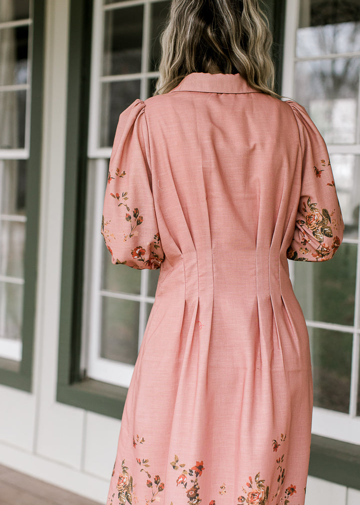 Back view of peach dress with pleating at the waist and shoulders, collar neck and 3/4 sleeves.