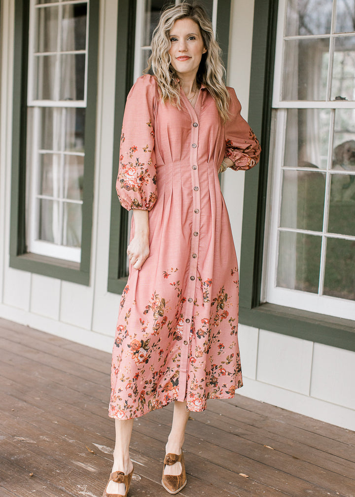 Model wearing heels and a peach dress with floral detailing, button front and 3/4 bubble sleeves. 